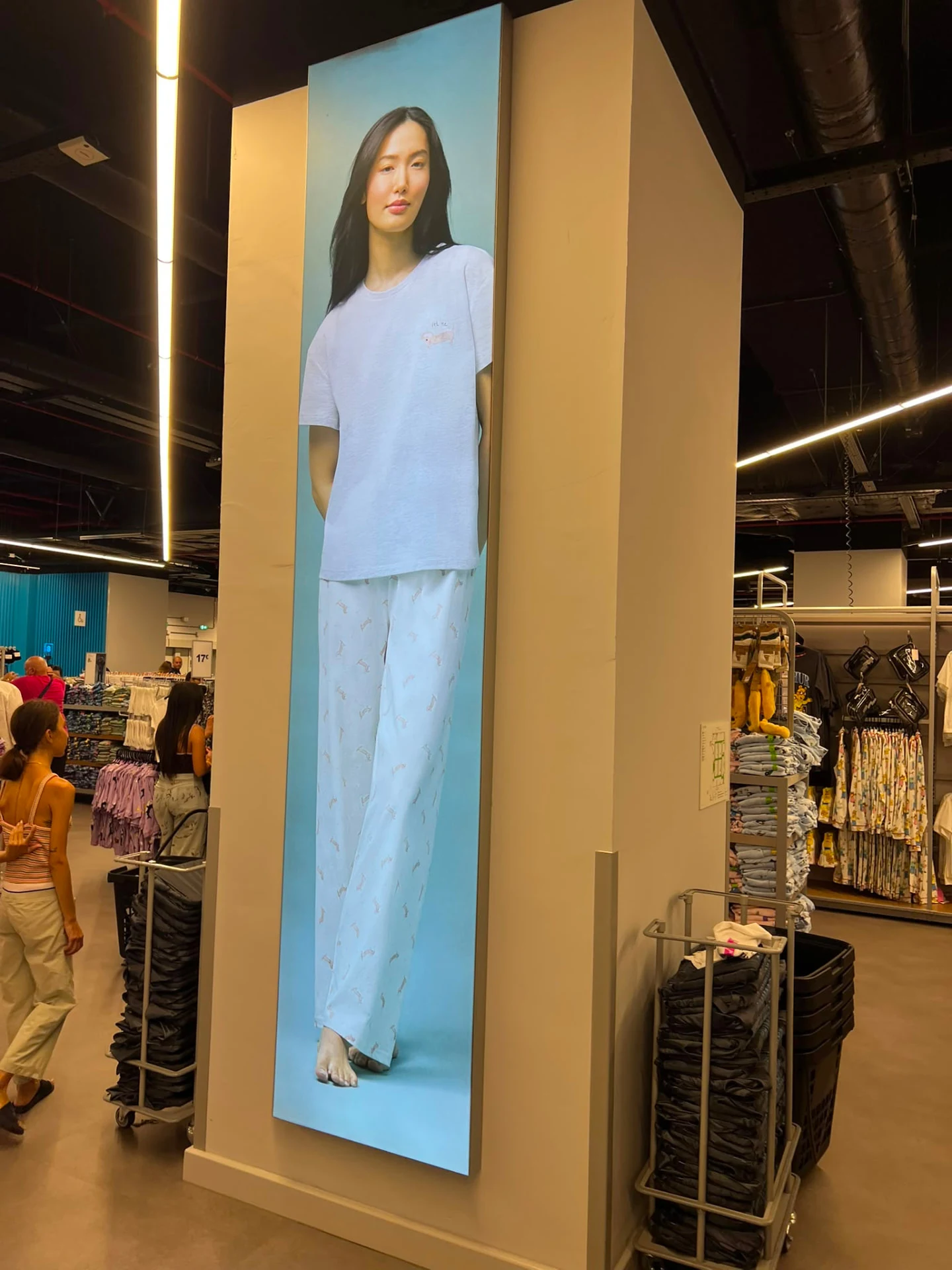 Tall illuminated campaign graphic on an in-store column