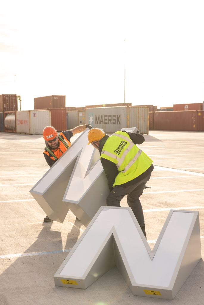 3:Rock experts installing signage on a crane