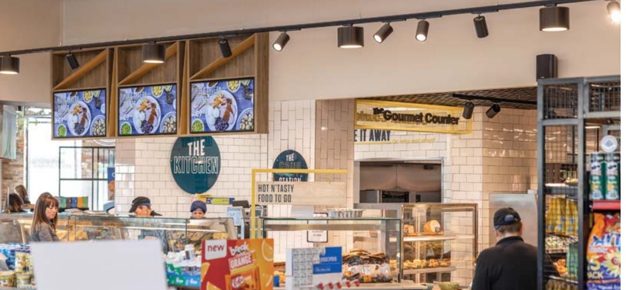 Custom yellow box-section cage and Gourmet Counter signage at Centra Clarina